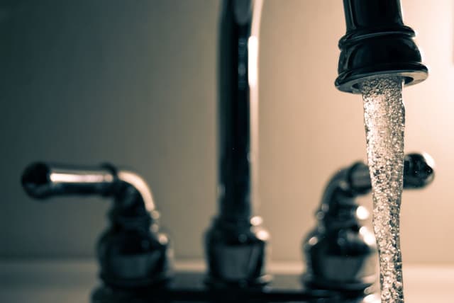 Water flowing from a steel faucet