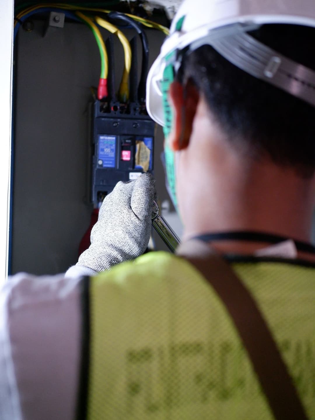 An electrician working safely on a circuit breaker box