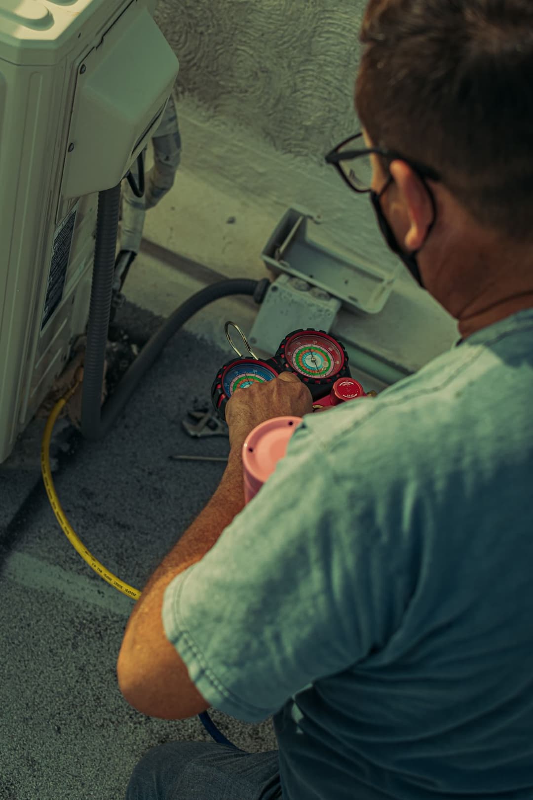A technician repairing an outdoor air conditioning unit